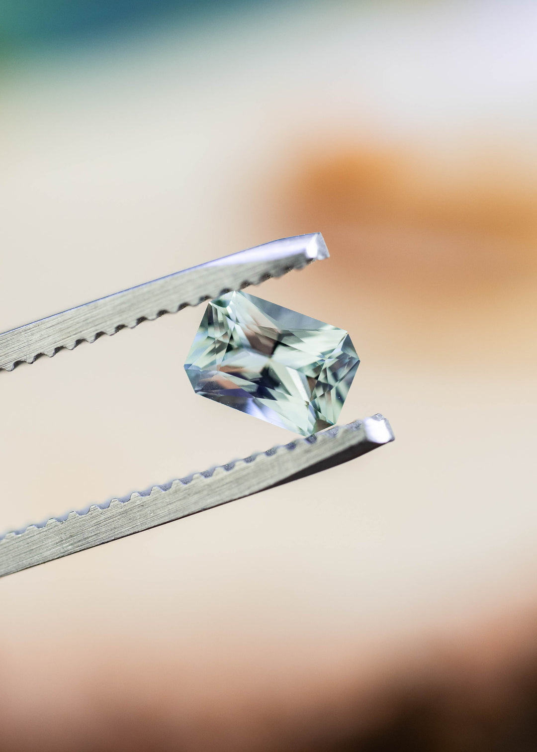 Close-up of an untreated 0.695 carat Montana sapphire showing its precision radiant cut and delicate seafoam green brilliance.