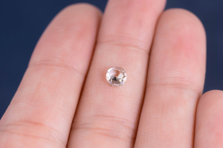 Close-up of a 0.80 carat Fancy Light Brown C3 VVS2 Mughal Cut diamond displayed on fingertips, highlighting antique faceting, clarity, and natural brilliance of this untreated South African stone.