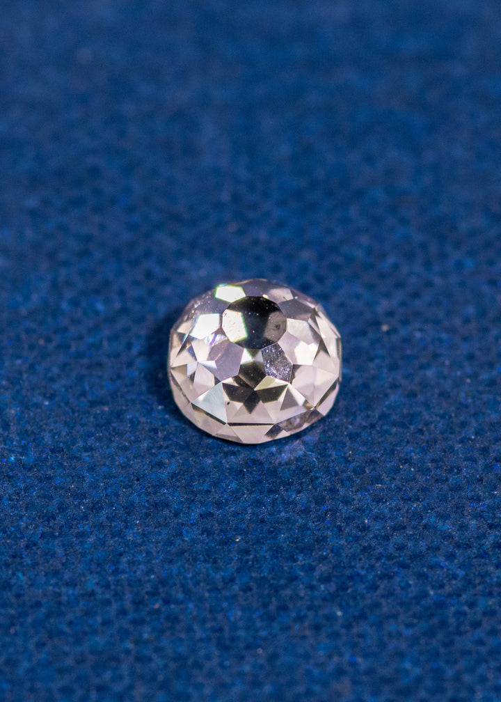 0.83ct Fancy Light Brown C2 VVS1 Mughal Cut Diamond from South Africa resting on blue textured background, showing antique-style faceting and high brilliance, untreated natural diamond.