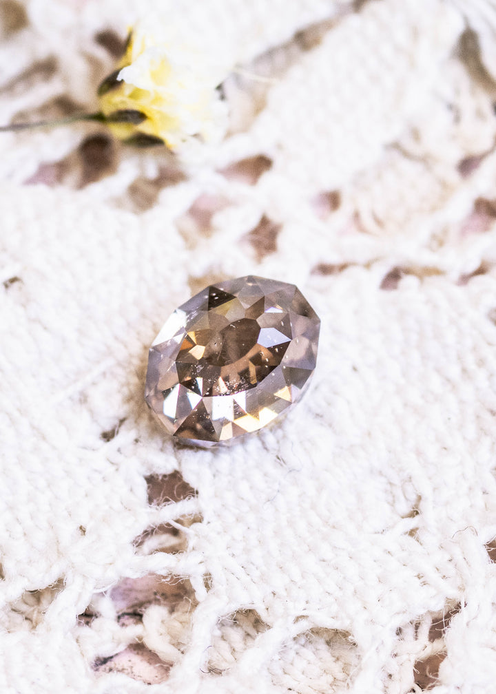Loose fancy light brown champagne diamond in Mughal cut shown face-up on lace, displaying its warm tone and geometric faceting.