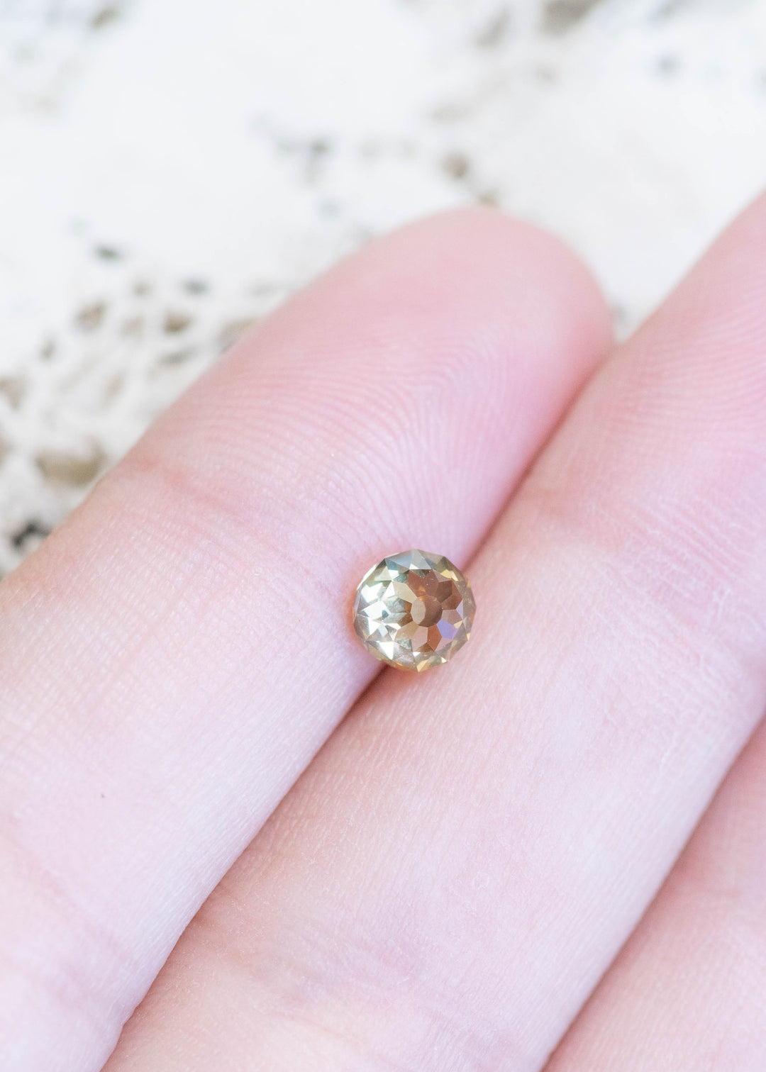 South African champagne diamond displayed on fingertips, emphasizing VVS2 clarity and warm golden-brown sparkle.