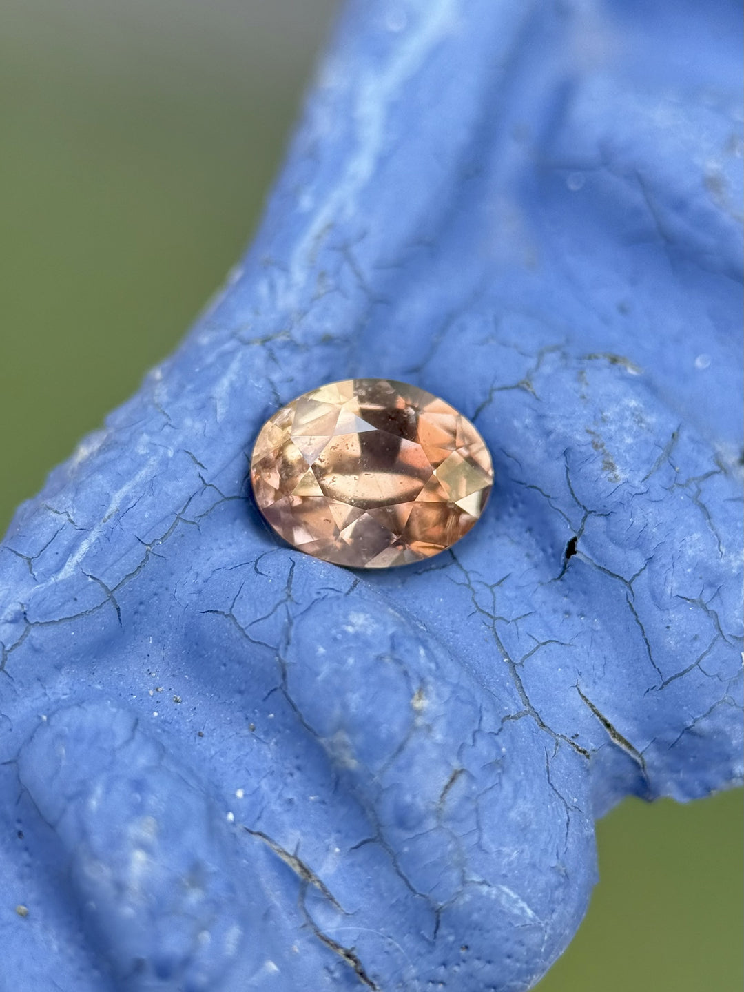 High-resolution image of natural Umba River sapphire, 0.95 carats, oval mix cut with orange, mauve, and pink hues – untreated and fluorescent.