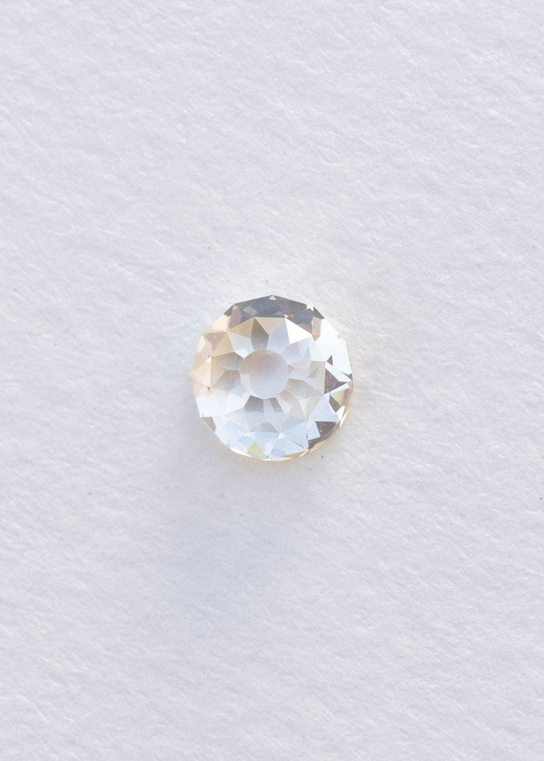 Face-up 0.99 carat round Mughal cut South African diamond on white, clearly showing its broad central table and individually shaped antique-style facets.
