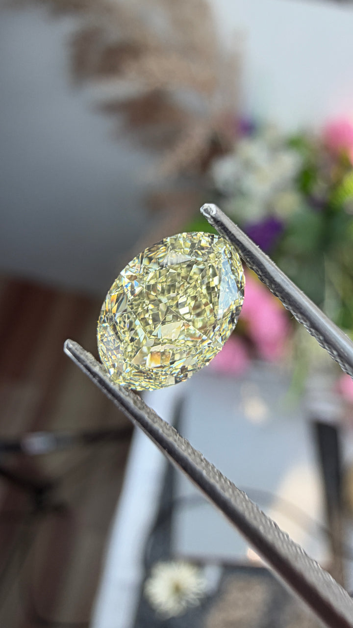 Detailed view of a 1.27ct Fancy Light Yellow oval diamond highlighting its faceting, elegant outline and delicate yellow coloration.
