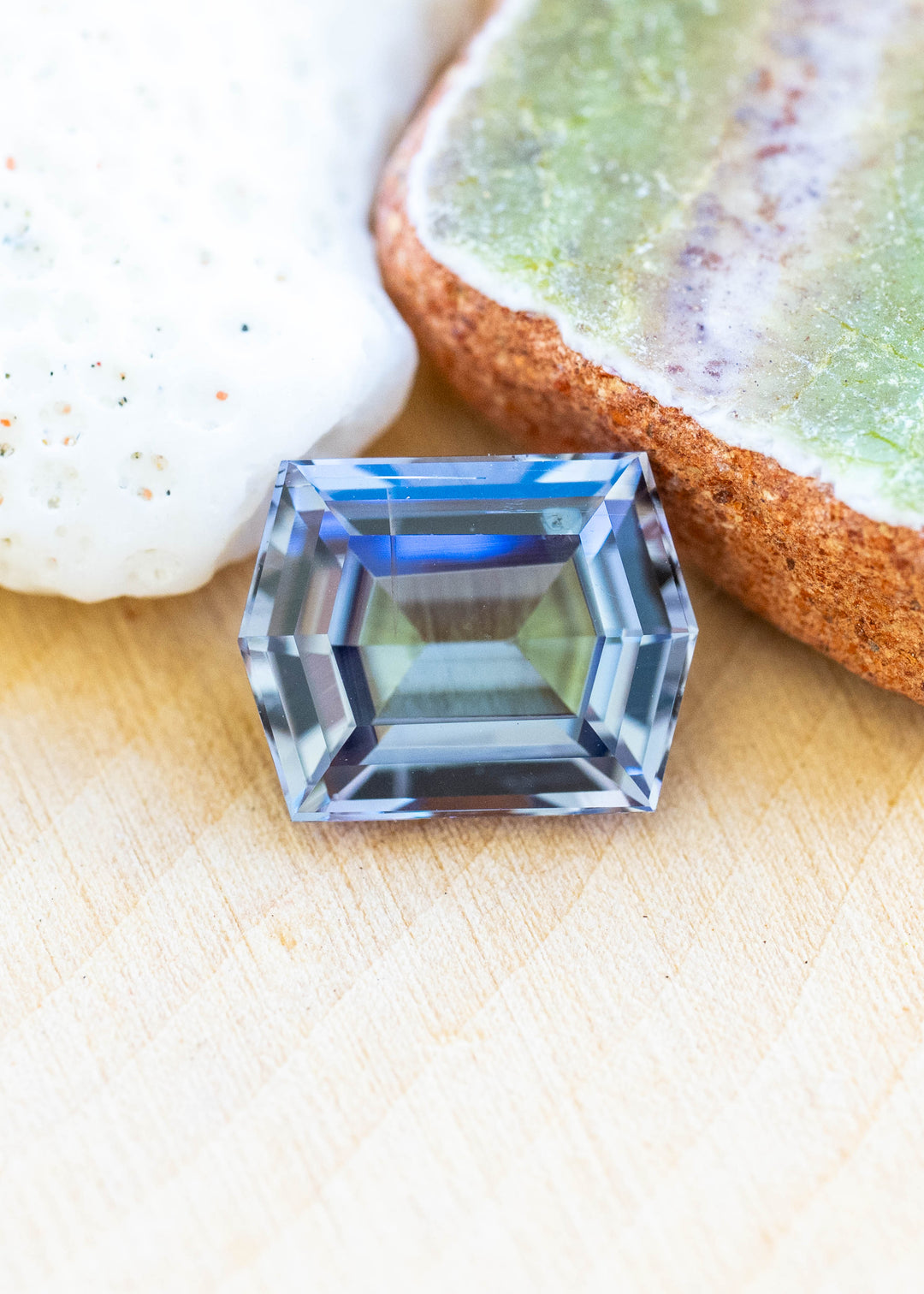 Natural 1.53 carat untreated Merelani Hills tanzanite displaying a custom geometric step cut hexagon with blue, green, and violet mermaid coloration.