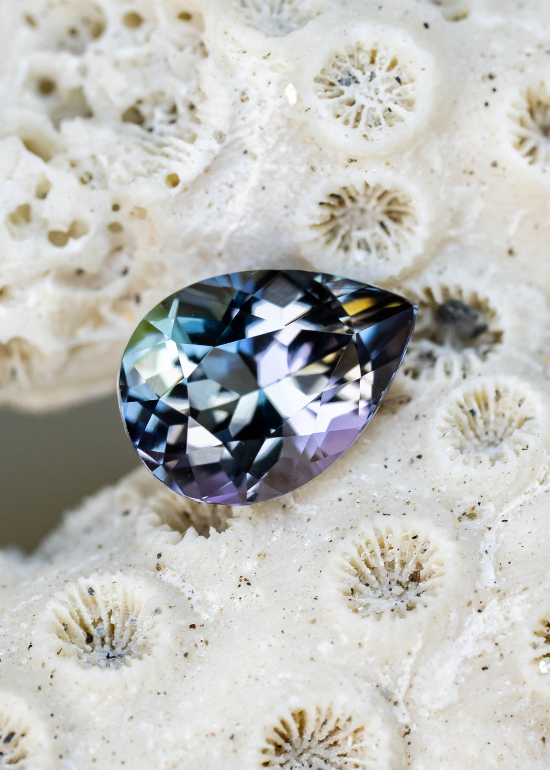 Natural 1.55 carat untreated Merelani Hills tanzanite featuring a modified mixed brilliant pear cut with blue, teal, green, purple, and golden color shifts.