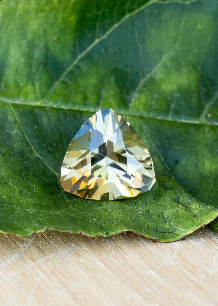 Natural 1.81 carat untreated tanzanite from Merelani Hills displaying teal, green and yellow hues in a custom brilliant trillion cut.