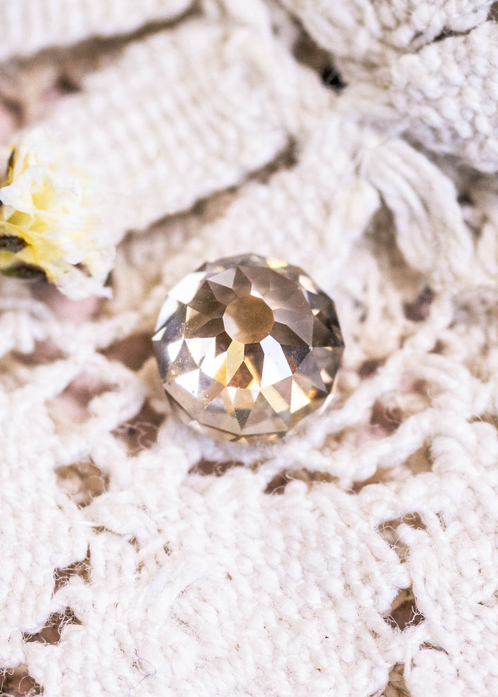 Loose rosy champagne fancy brown Mughal cut diamond displayed face-up on lace, showing its warm brown tones and intricate antique-style faceting.