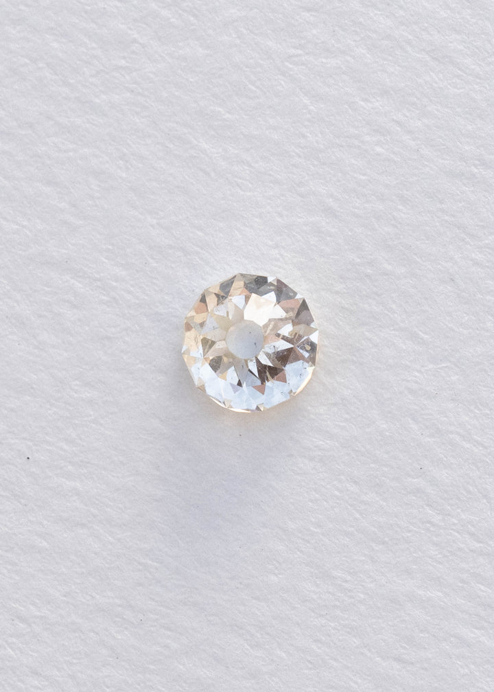 Face-up South African Mughal cut diamond on a white background, clearly showing its nearly round outline, circular central table, irregular radial facets and natural inclusions.