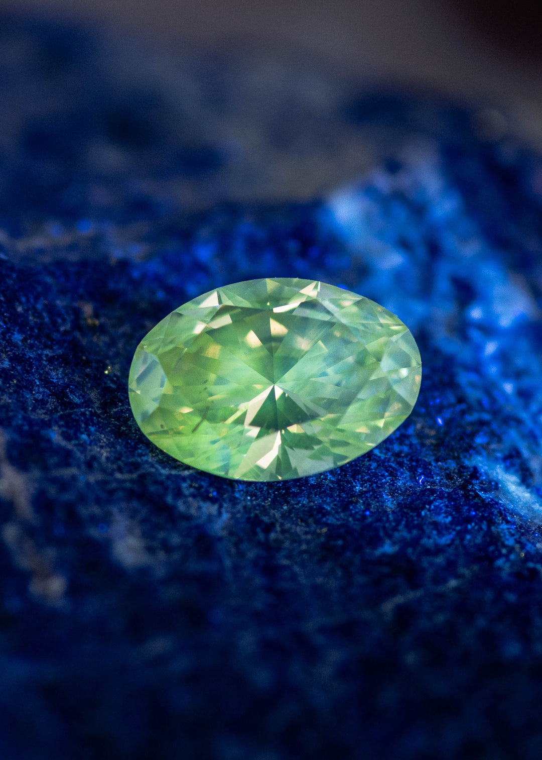 Oval diamond under UV light displaying rare green fluorescence, natural fluorescent diamond gemstone.