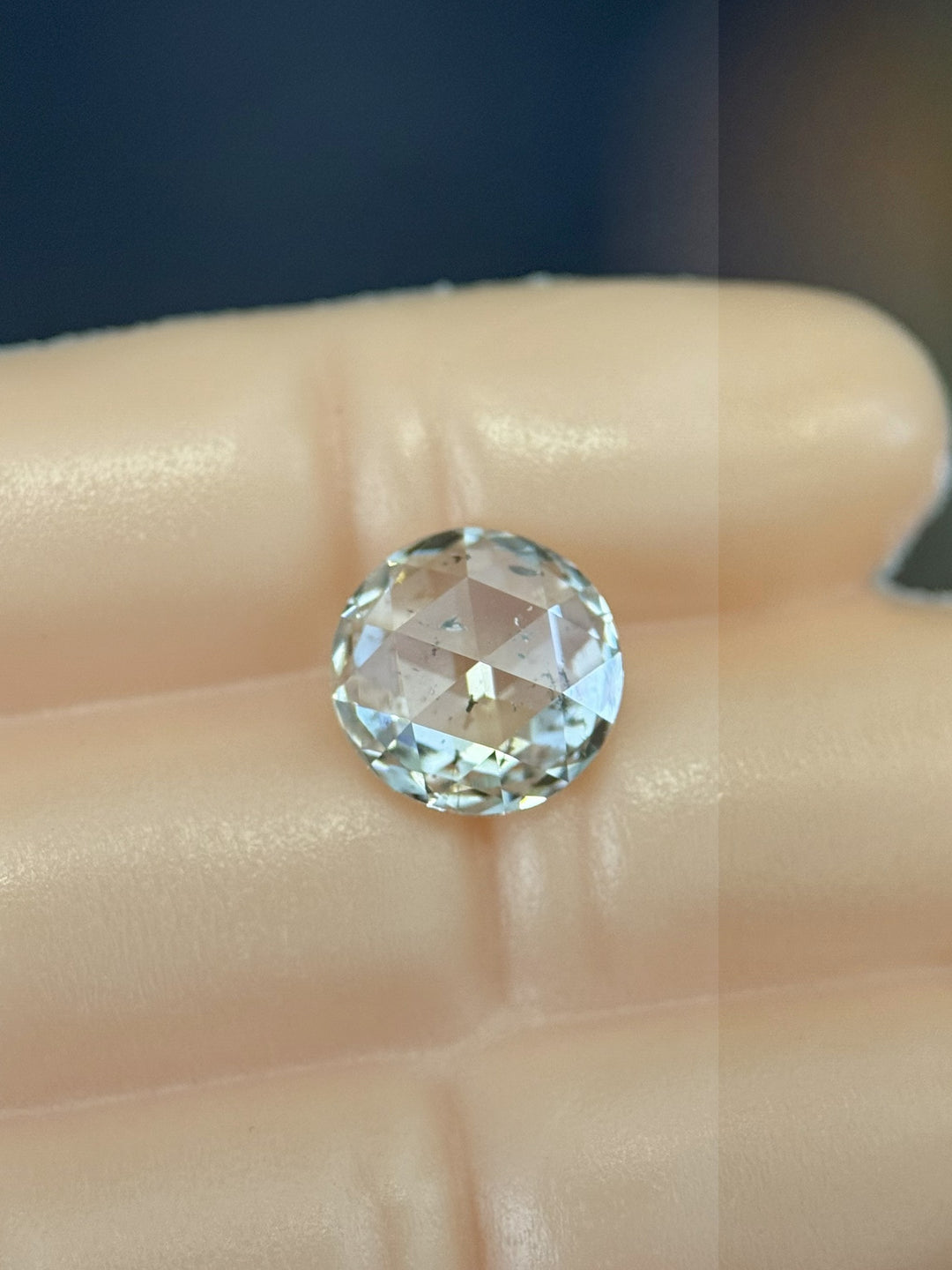 1.04 carat natural diamond resting on a hand, showcasing its round rose cut facets and bright F color clarity I1 sparkle, ethically sourced from the Gahcho Kué Mine in Canada, untreated and natural.