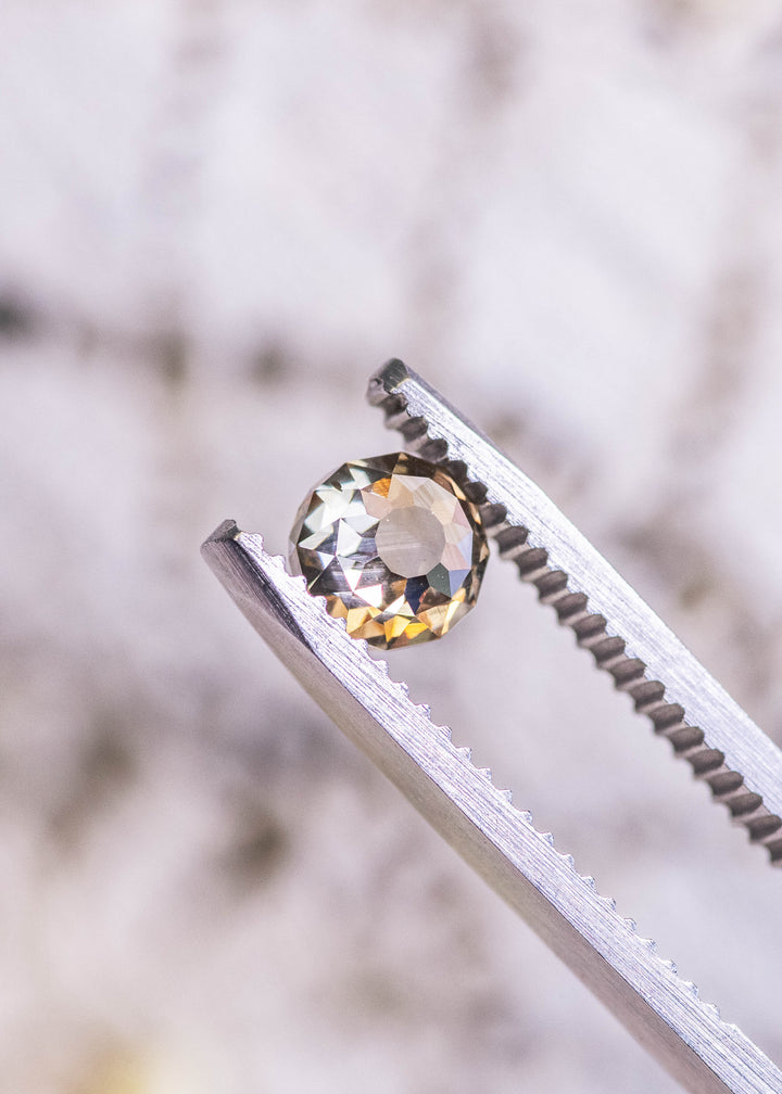 1.04 carat Mughal cut diamond with champagne fancy yellow brown color and blue fluorescence held in tweezers