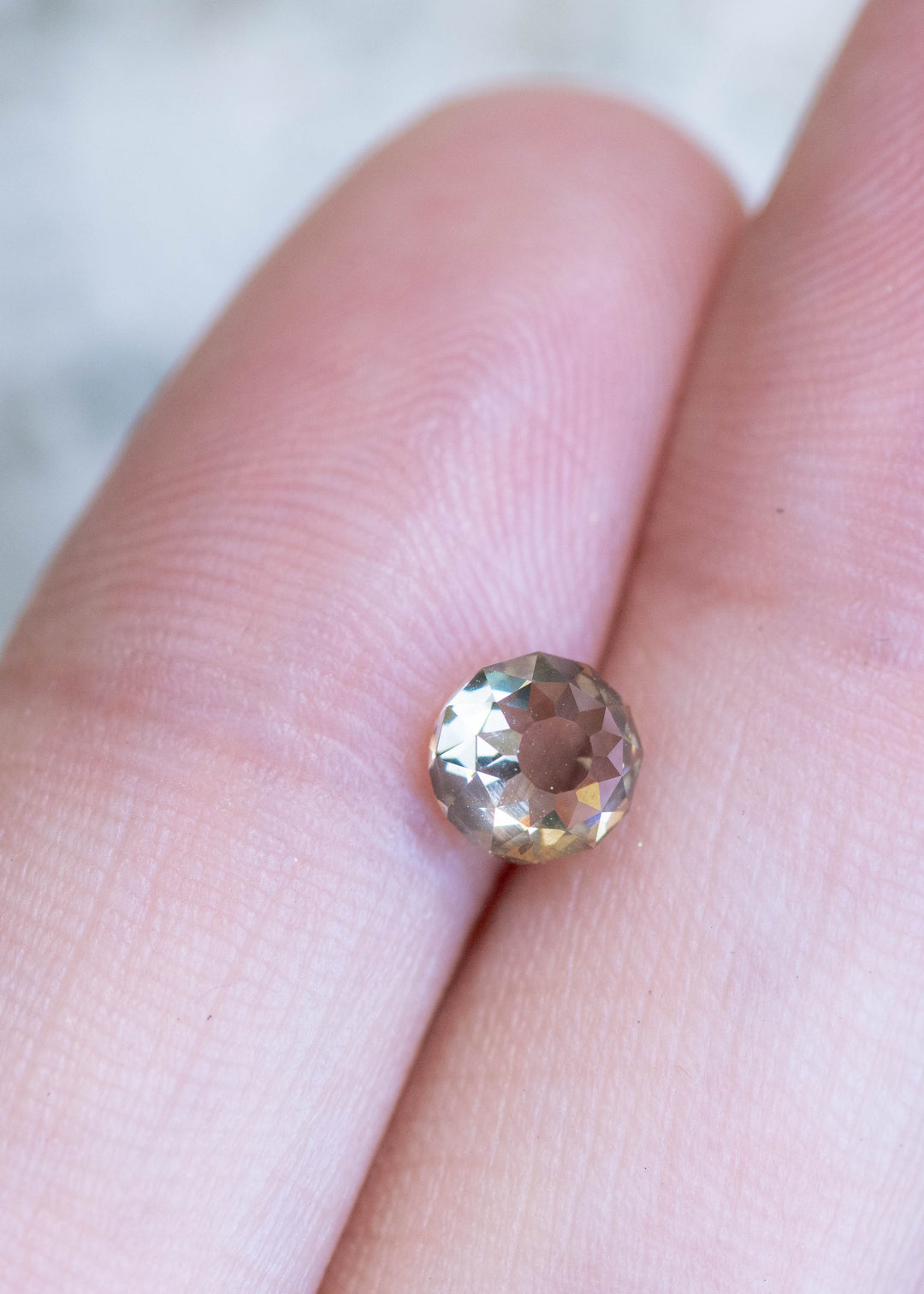 Loose Mughal cut diamond with champagne brown color resting on hand showing antique faceting and fluorescence