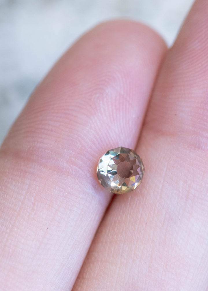 Loose Mughal cut diamond with champagne brown color resting on hand showing antique faceting and fluorescence