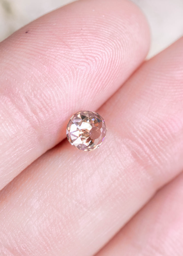 Loose 1.08 carat fancy brown diamond resting on fingertips, showing the Mughal cut and soft champagne hue with natural brilliance.