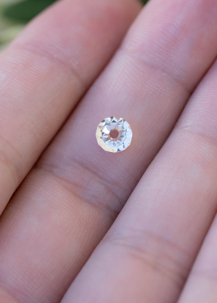 1.09 carat round Mughal cut diamond resting on a fingertip for scale, displaying its 5.67 × 5.62 mm face-up proportions and distinctive central table.