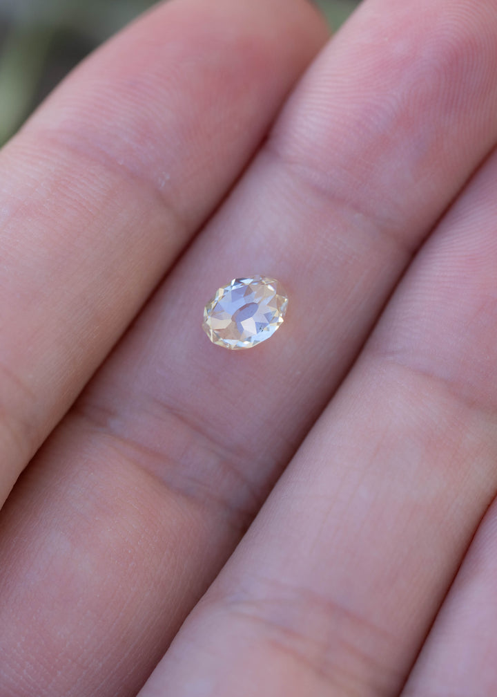 1.09 carat oval Mughal cut diamond resting on a fingertip for scale, displaying its warm ivory tone, elongated proportions and natural inclusions.