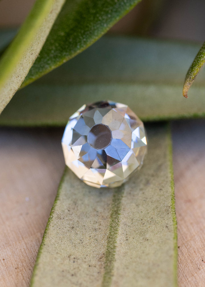 Close-up face-up view of a 1.11 carat round Mughal cut diamond among leaves, showing its broad central table and softly irregular radial faceting.