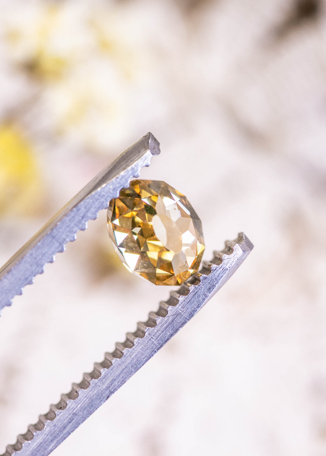 Loose 1.12 carat fancy yellow brown Mughal cut diamond from South Africa held in tweezers, showing the rounded Mughal profile and warm champagne color.
