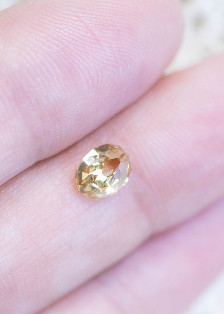 Loose 1.12 carat champagne fancy yellow brown Mughal cut diamond from South Africa resting on fingertips, displaying scale, clarity, and natural brilliance.