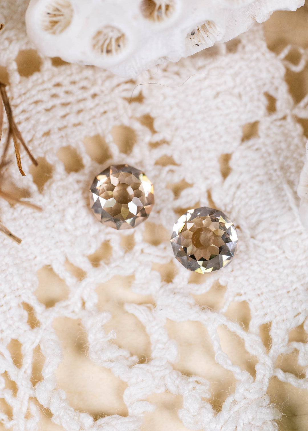 A pair of Round Mughal cut diamonds from South Africa, weighing 1.13 carats total. Photographed on ivory lace, their C4 champagne coloration, VVS1 clarity, and unusual geometric faceting create a distinctive antique-inspired appearance.