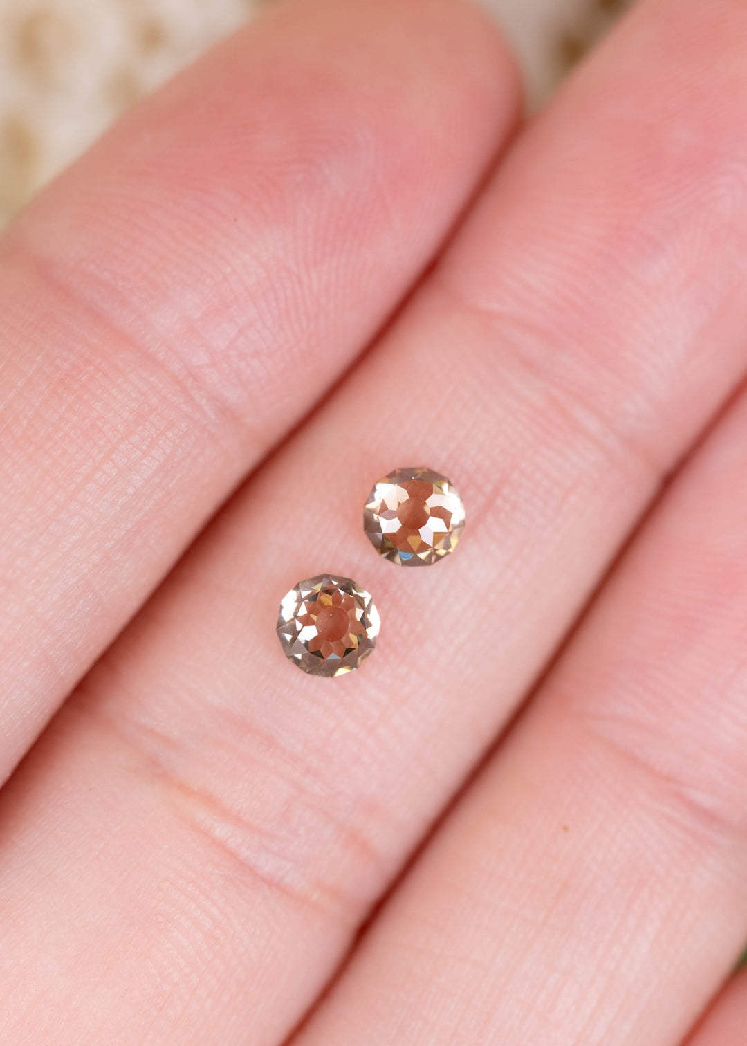 A matched pair of 1.13ct total weight C4 champagne diamonds photographed on fingers for scale. Their Round Mughal cuts reveal geometric reflections and warm, transparent-looking centers, ideal for bespoke diamond earrings.