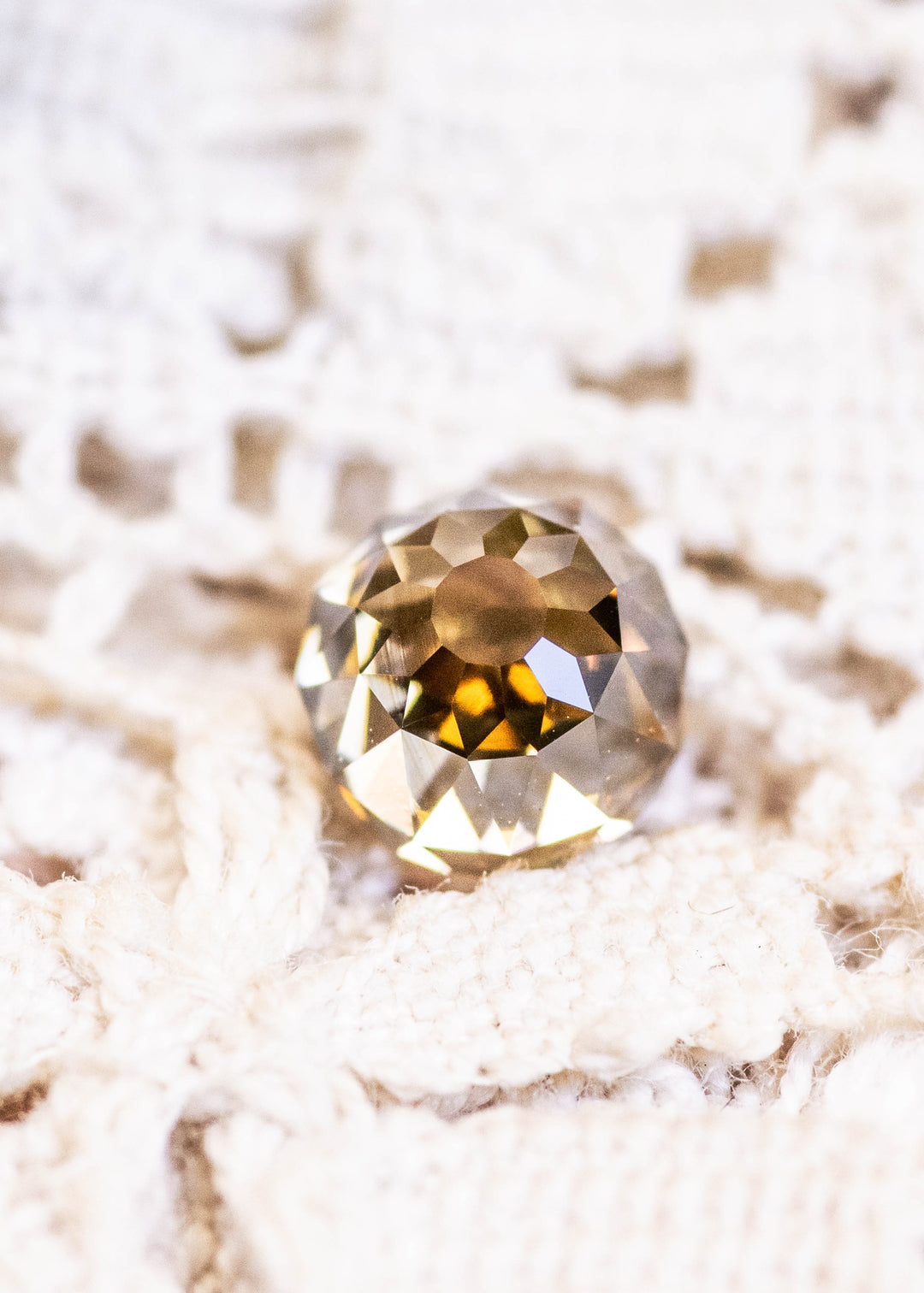 Loose 1.14 carat fancy yellow brown Mughal cut diamond from South Africa shown face-up, displaying its antique faceting and warm champagne tone.