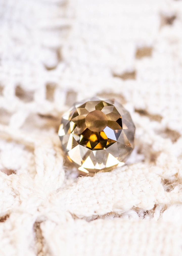 Loose 1.14 carat fancy yellow brown Mughal cut diamond from South Africa shown face-up, displaying its antique faceting and warm champagne tone.