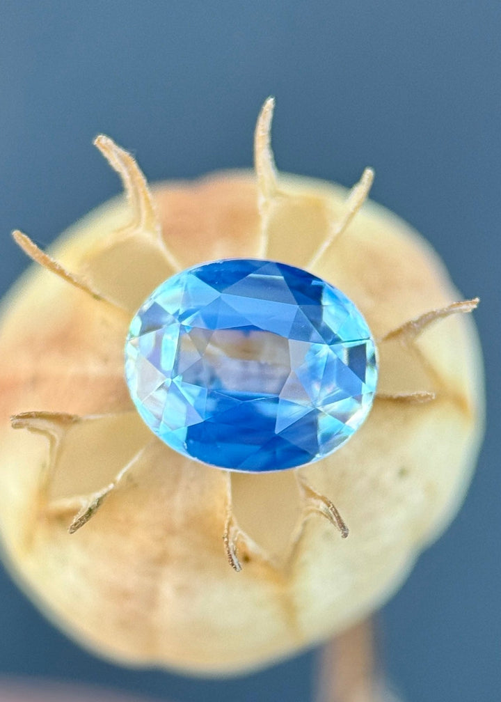 1.15 carat opalescent powder blue sapphire shown face-up, displaying precision oval faceting and soft pastel blue color from Diego, Madagascar.