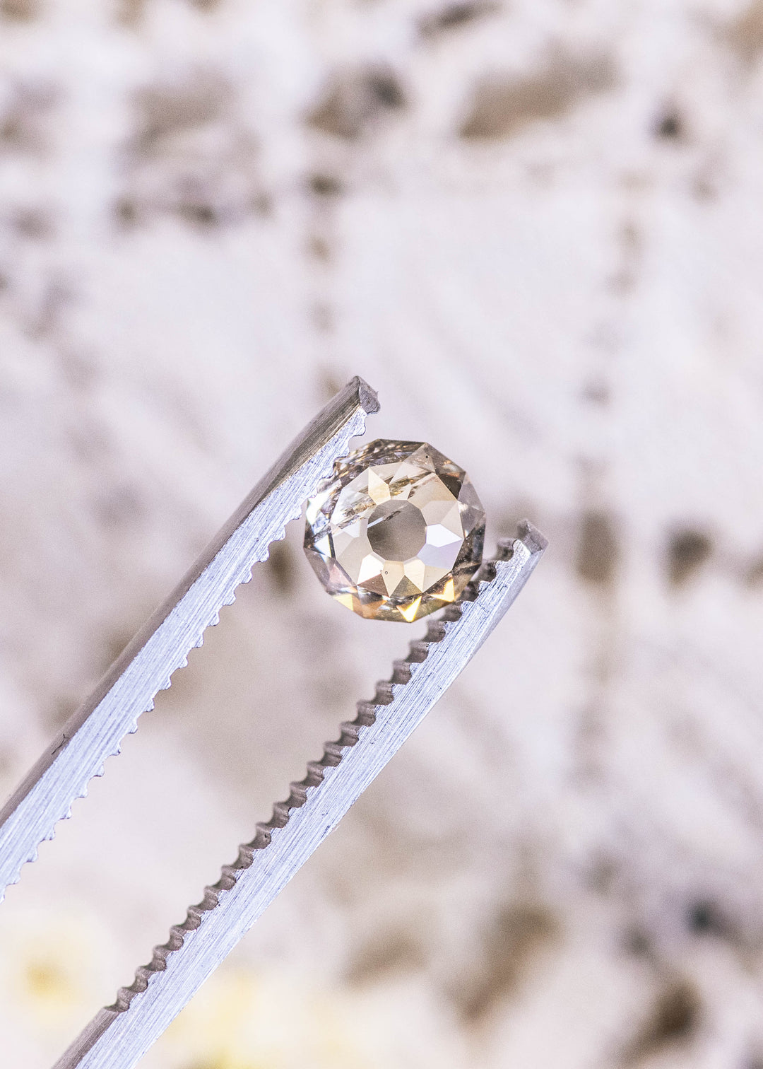 Loose champagne fancy light brown Mughal cut diamond held in tweezers, highlighting its faceted dome and distinctive antique-inspired design.