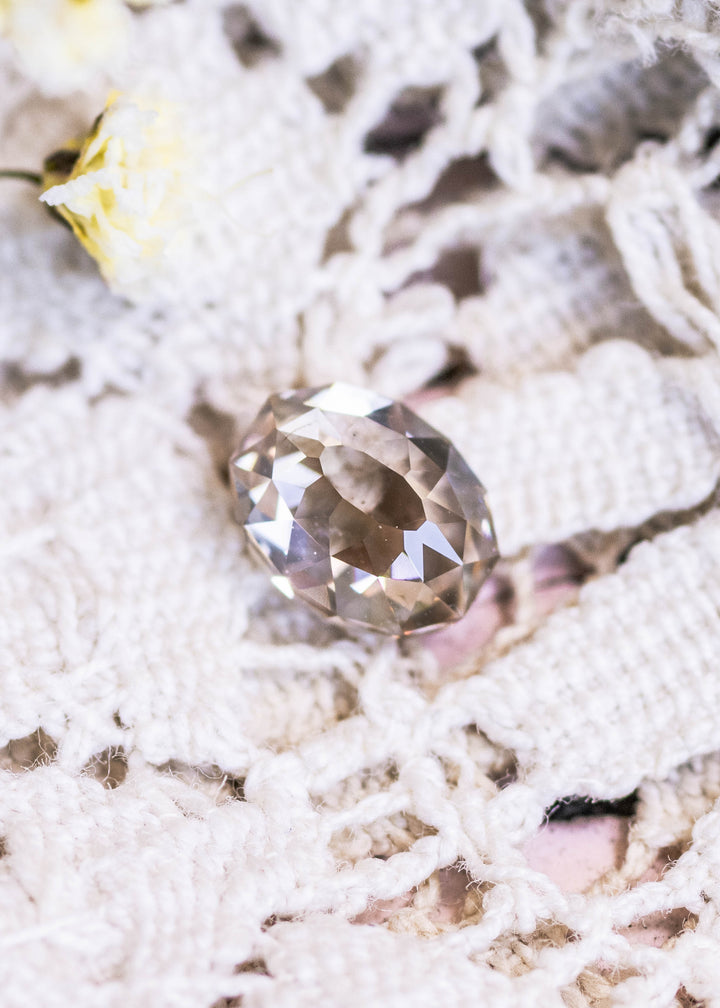 Loose 1.18 carat champagne fancy light brown Mughal cut diamond from South Africa shown face-up on lace, displaying its soft warm tone and faceted dome.