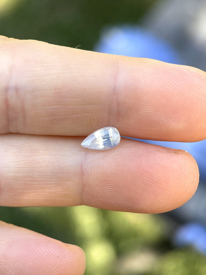Pear-cut sapphire glowing softly in natural sunlight.