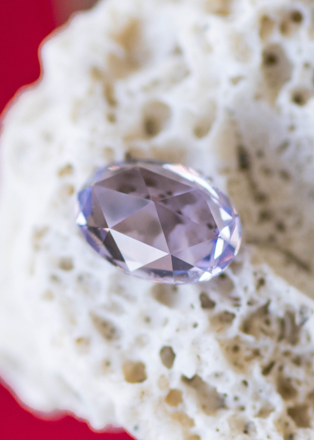 1.19 carat lavender purple pink sapphire shown face-up, displaying precision oval rose cut faceting and vibrant pastel color from Saka Raha, Madagascar.