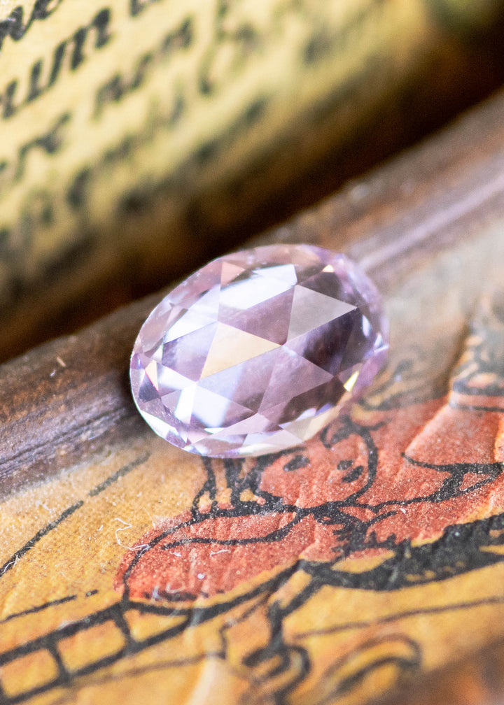 1.21 carat opalescent violet purple pink rose cut sapphire shown face-up, displaying soft lavender and rose tones with oval rose cut faceting from Sakaraha, Madagascar.