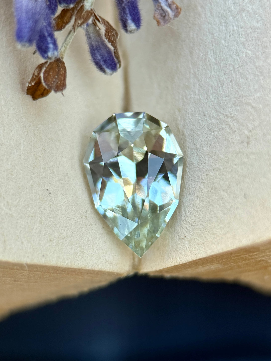1.24 carat light seafoam green sapphire shown face-up, displaying precision pear cut faceting and soft ocean-inspired color from Madagascar.