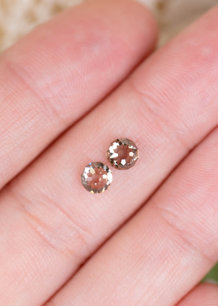 A 1.32ct total weight pair of C1–C3 champagne diamonds photographed on fingers for scale. Their complementary colors and unusual Round Mughal faceting make them appealing for custom diamond earrings and bespoke fine jewelry.