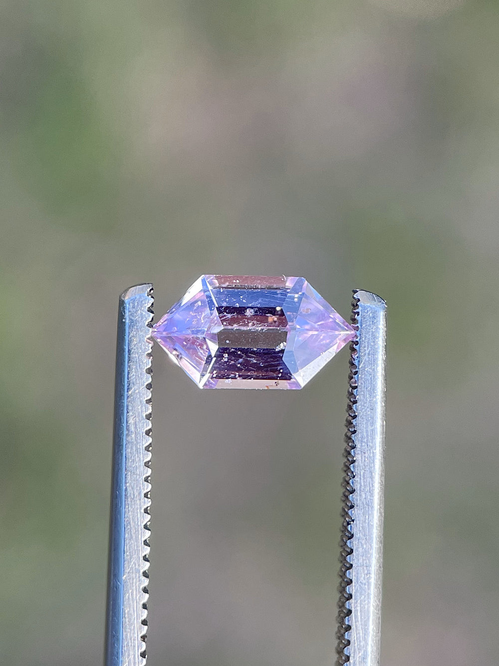 A unique 1.33-carat step cut hexagon sapphire with a mesmerizing blend of pink, lavender, and champagne tones, sourced from Madagascar.