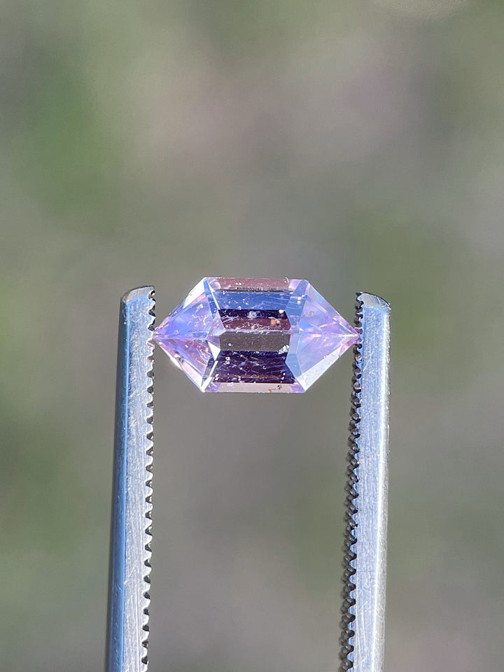 A unique 1.33-carat step cut hexagon sapphire with a mesmerizing blend of pink, lavender, and champagne tones, sourced from Madagascar.