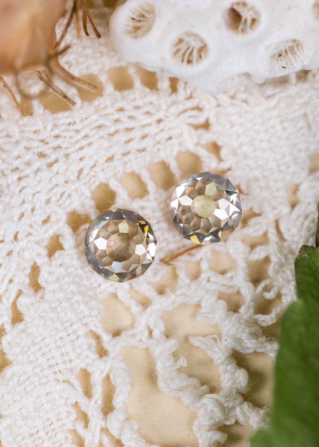 A matched pair of South African Round Mughal cut diamonds with a combined weight of 1.41 carats. Photographed on vintage white lace, their C3 champagne coloration, distinctive faceting, and softly rounded silhouettes are highlighted in natural light.