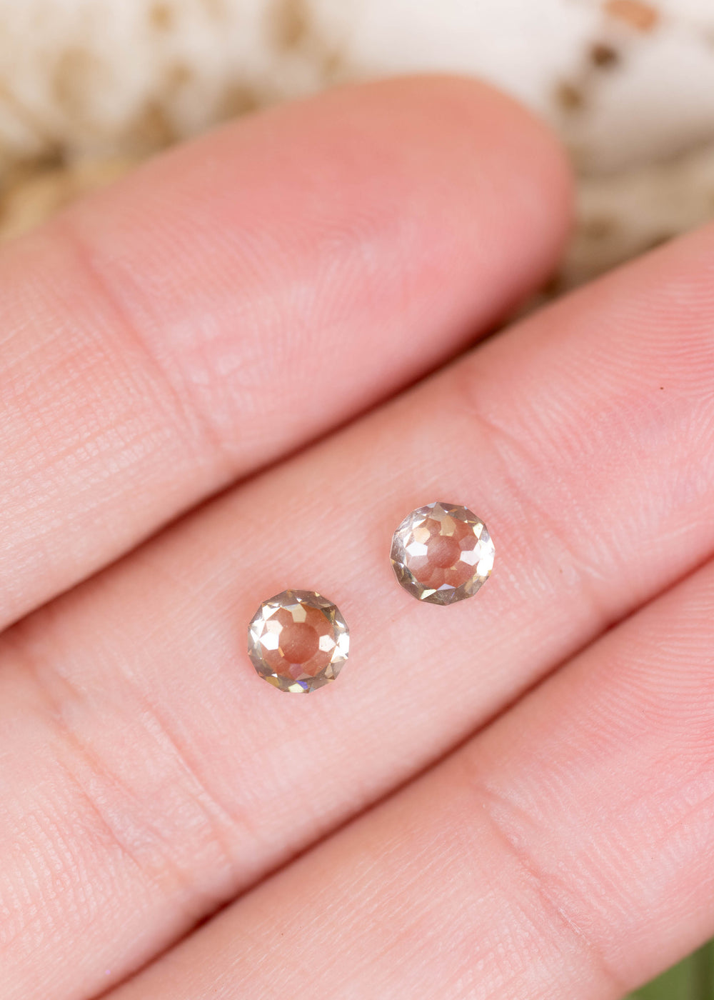 A matched pair of 1.41ct total weight Round Mughal cut diamonds photographed on fingers for scale. Their warm champagne color, unusual faceting, and closely matched proportions make them ideal for custom earrings and bespoke fine jewelry.