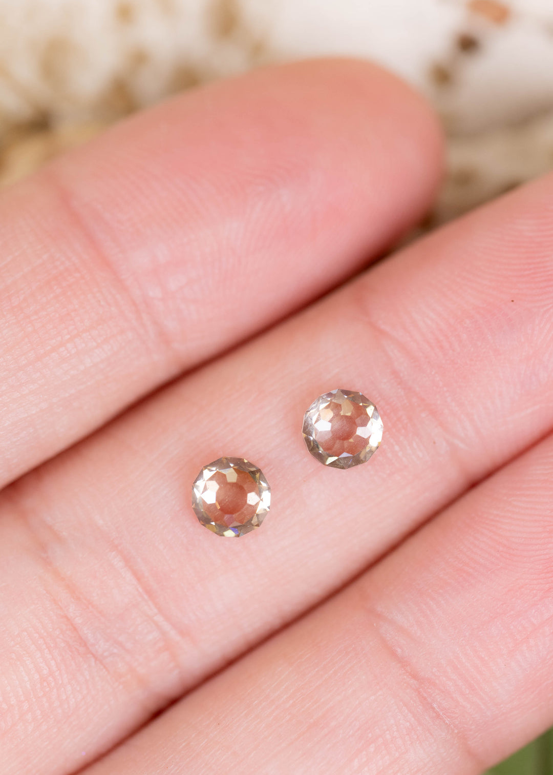 A matched pair of 1.41ct total weight Round Mughal cut diamonds photographed on fingers for scale. Their warm champagne color, unusual faceting, and closely matched proportions make them ideal for custom earrings and bespoke fine jewelry.