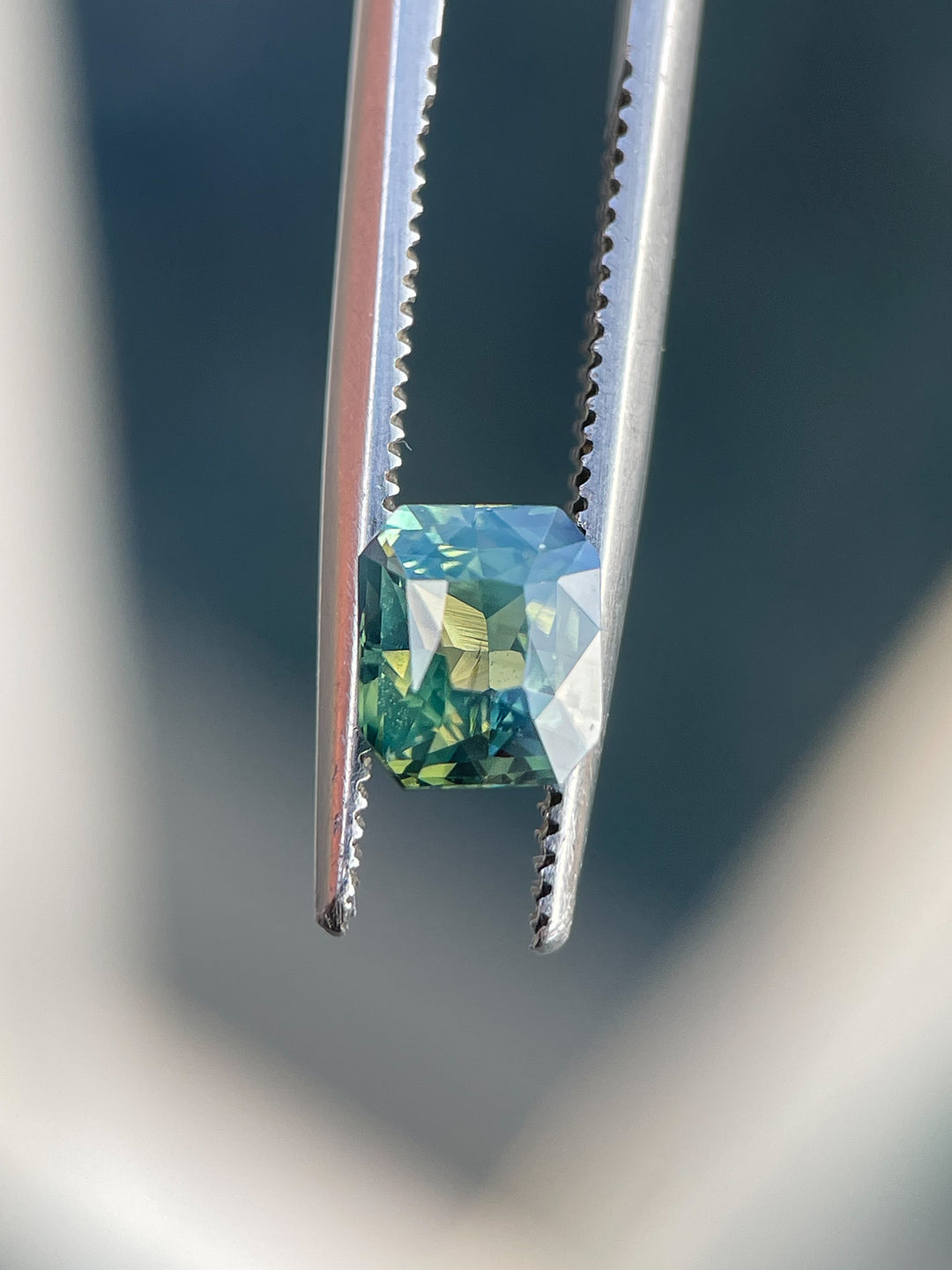 A striking 1.42-carat sapphire showcasing opalescent yellow, teal, and green hues. Cut in a radiant shape, this gemstone is untreated and ethically sourced from Madagascar.