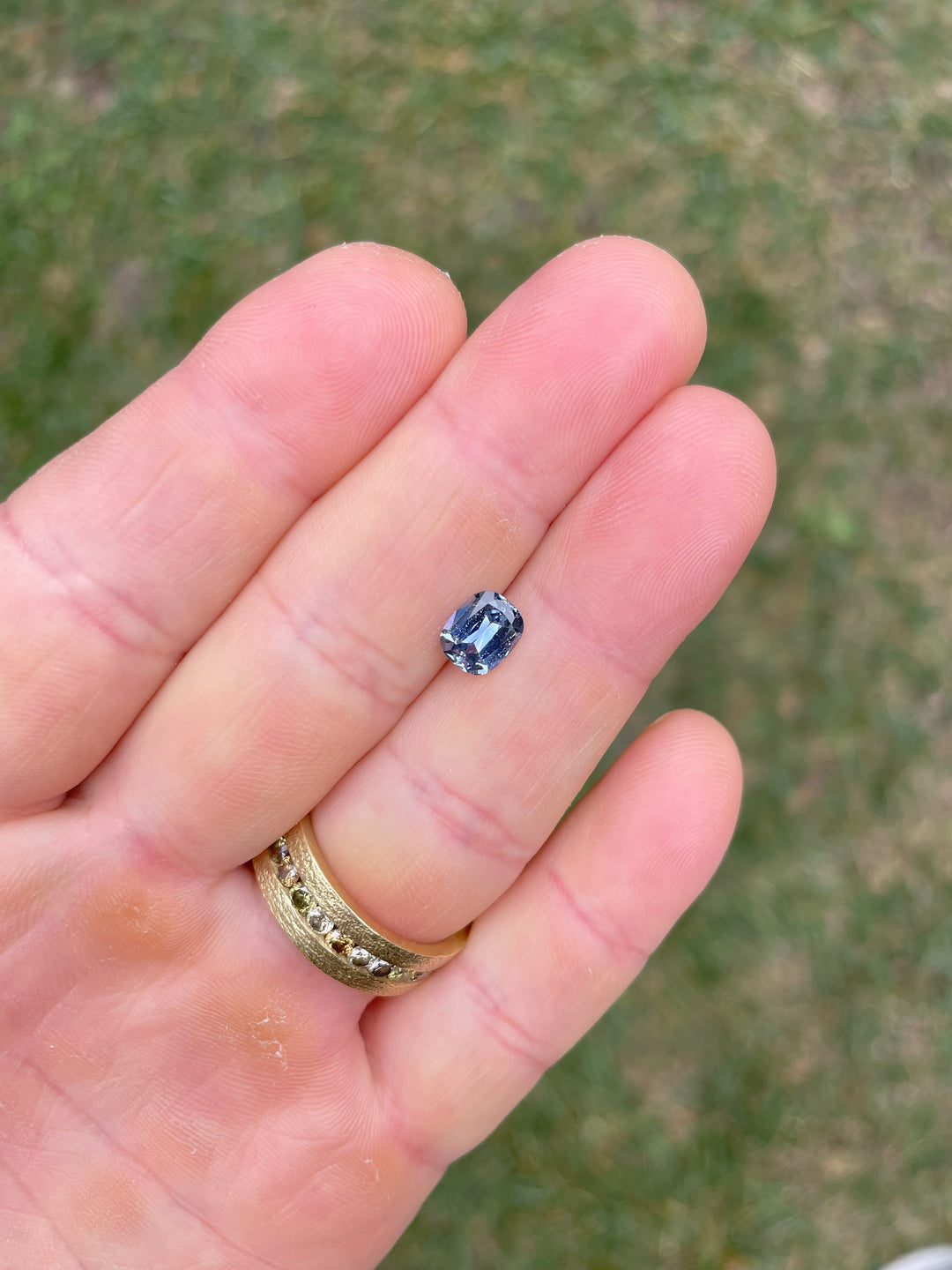 Top view of a 1.48-carat Sri Lankan sapphire in denim blue and cornflower hues, cushion modified cut, reflecting natural light.