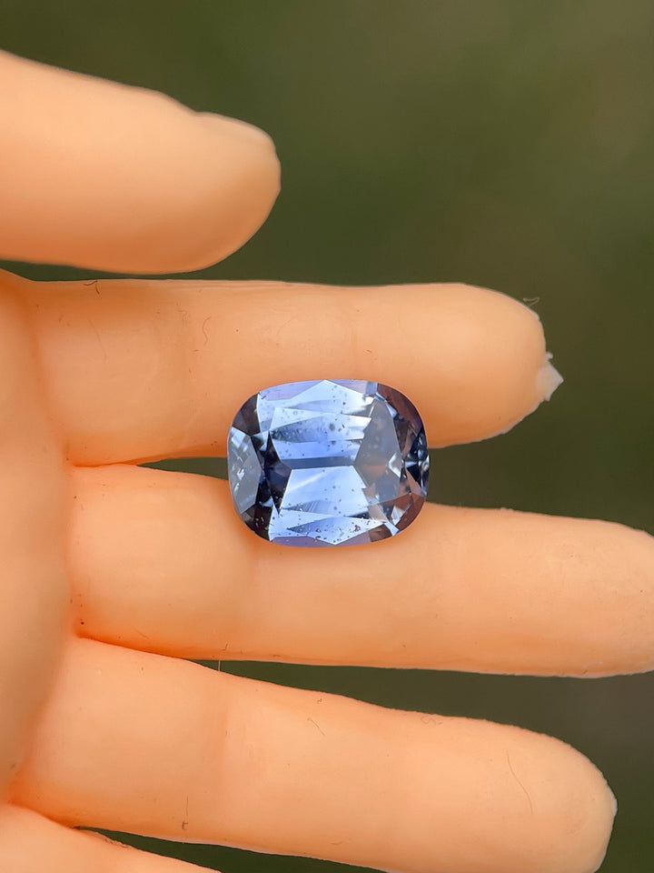 Hand-held view of a 1.48-carat sapphire in a blend of denim blue and cornflower tones, untreated, from Sri Lanka, in a modified cushion cut.
