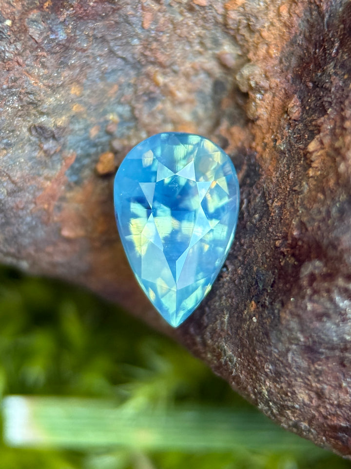 1.50 carat opalescent teal blue green sapphire shown face-up, displaying pear mixed cut faceting and luminous ocean-inspired color from Diego, Madagascar.