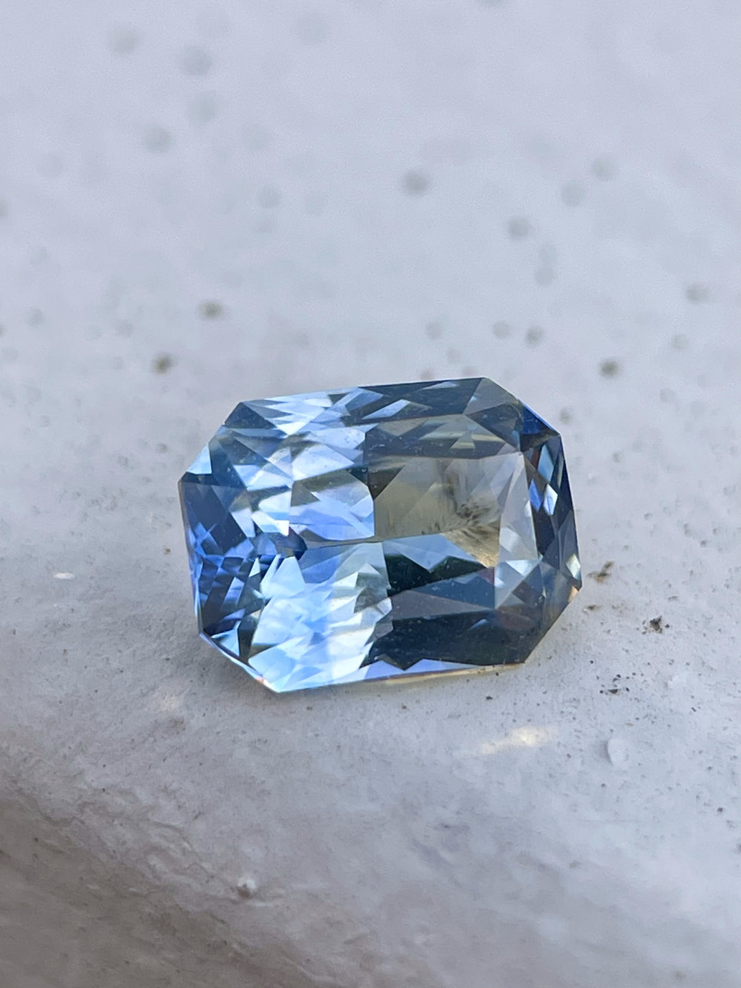 A 1.52-carat parti sapphire showcasing a radiant cut with mesmerizing hues of blue, yellow, teal, and green. Ethically sourced from Sri Lanka, this untreated gemstone reveals a harmonious blend of colors.