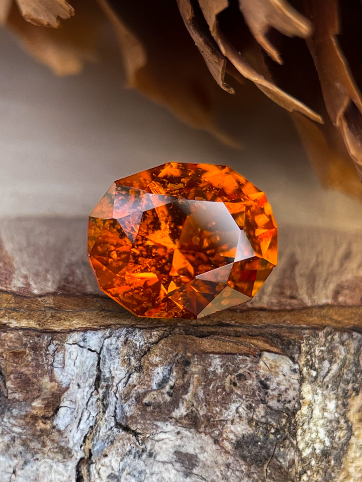 Stunning 1.61-carat Hessonite Garnet in vibrant orange-brown color with a custom geometric oval cut, sourced from Kenya.