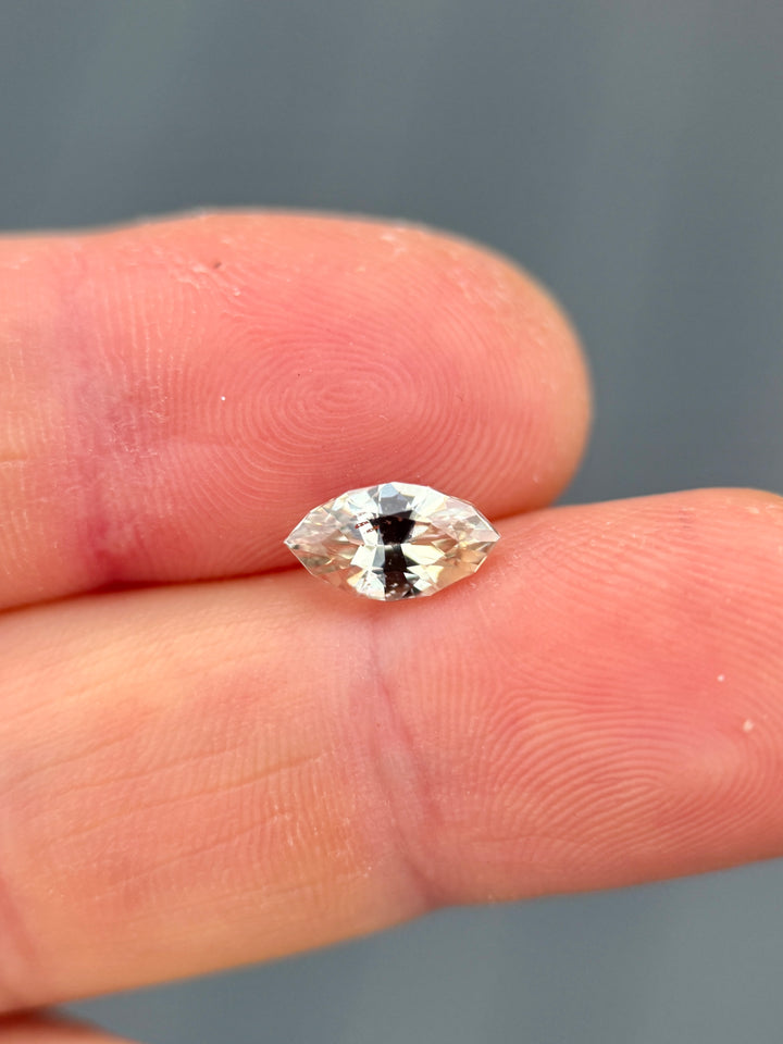 1.61 carat yellow sapphire displayed on fingertip in natural light, showcasing its radiant yellow hue and expert precision marquise mixed cut, untreated sapphire from Sakaraha, Madagascar.