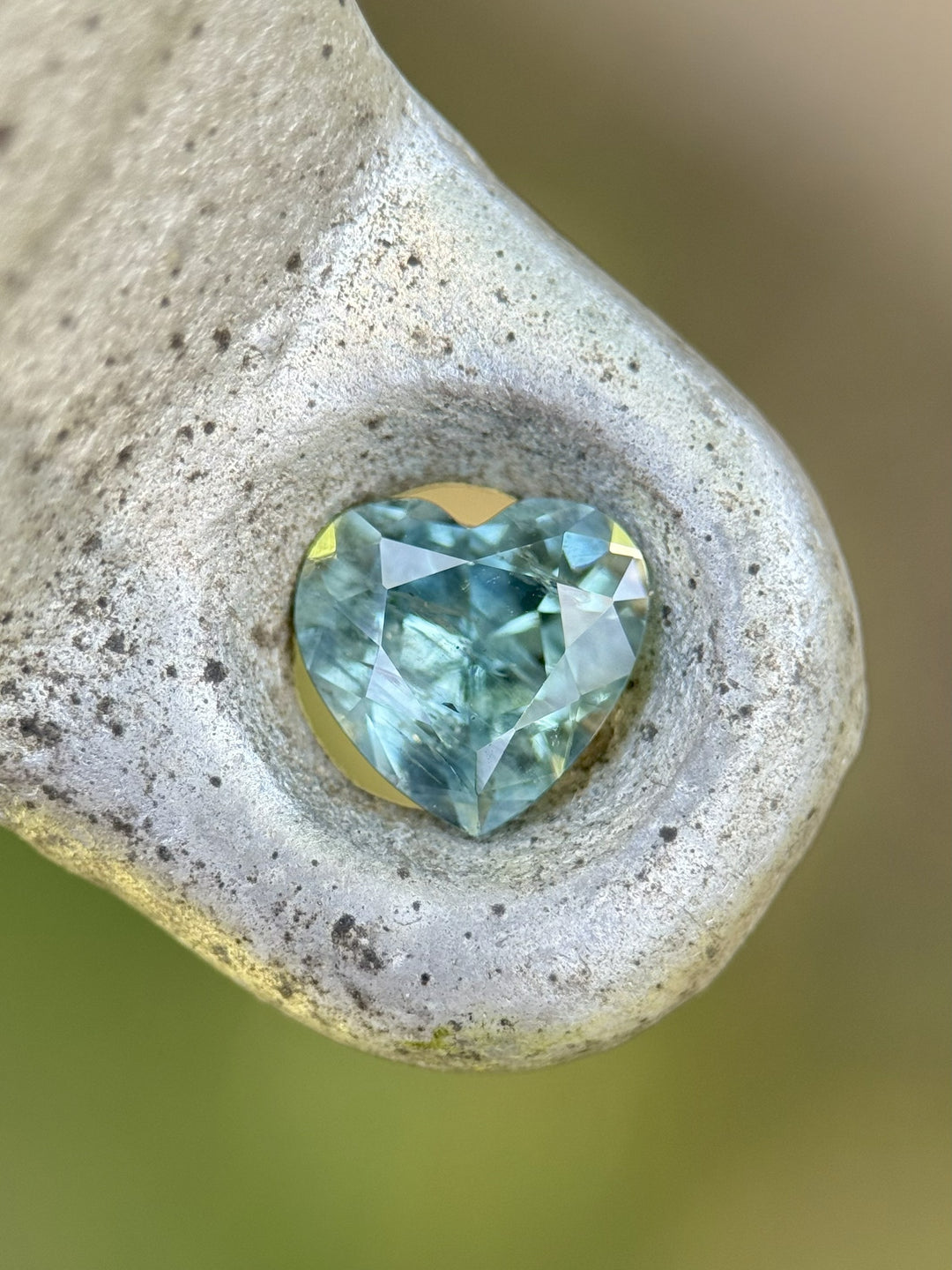 Heart-shaped teal green sapphire displayed in natural stone setting – 1.71ct, Montana origin.