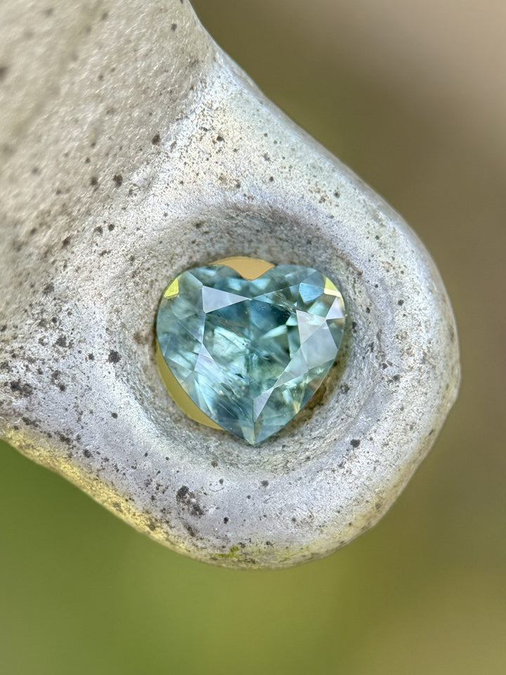 Heart-shaped teal green sapphire displayed in natural stone setting – 1.71ct, Montana origin.